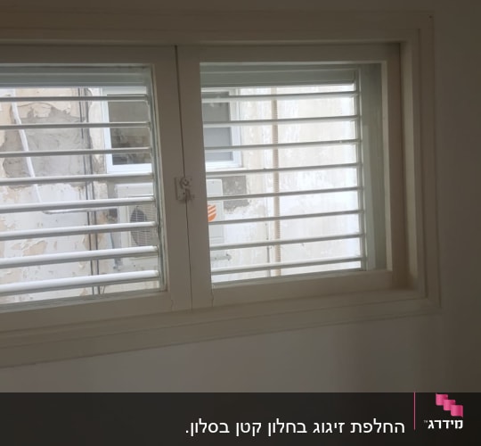חלון זכוכית עם תריסים לבנים